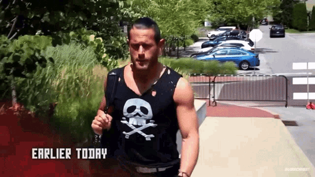 a man wearing a black tank top with a skull and crossbones on it is running