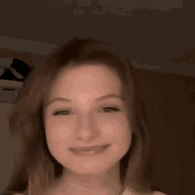 a woman is smiling and giving a thumbs up sign .
