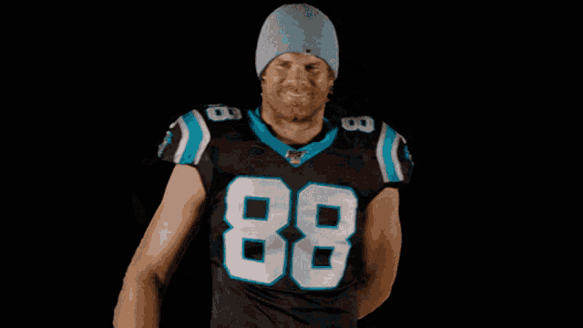 a man wearing a number 88 jersey high fives another man