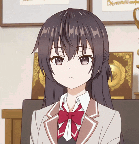 a girl with long black hair and a red bow tie looks angry