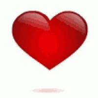 a red heart is floating in the air on a white background .