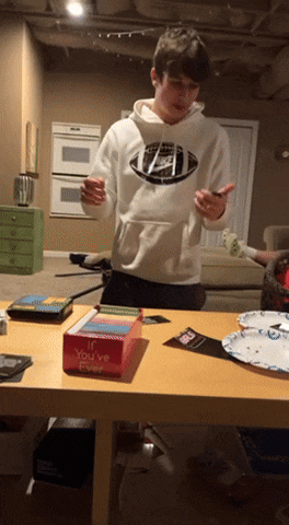 a boy in a nike sweatshirt stands in front of a table with a box that says you 've ever