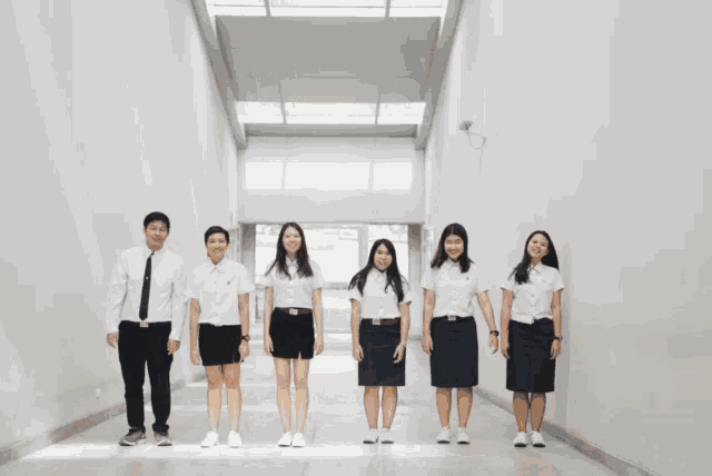 a group of graduates are standing in a hallway holding hands