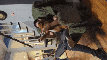 a man sits in a chair holding a dog