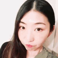 a woman with long black hair is taking a selfie with her face in the foreground .