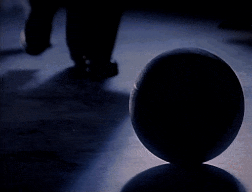a person is walking past a basketball on the floor