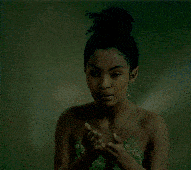 a naked woman is holding something in her hands and looking at it