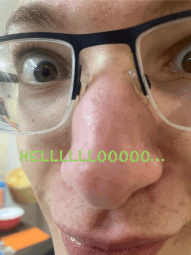a close up of a person 's face with glasses and the words hello written on it