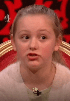 a young girl is sitting in a chair with a microphone on her neck and making a funny face .