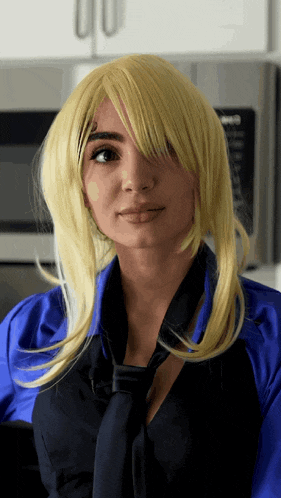 a woman wearing a blonde wig and a blue shirt and tie