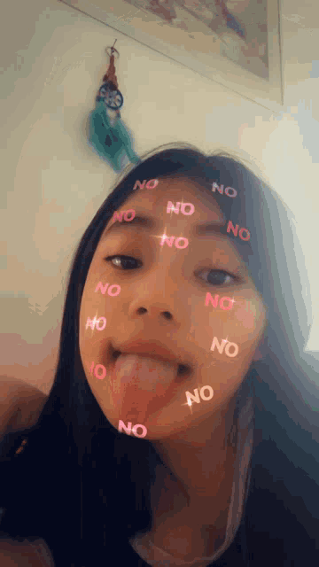 a girl is sticking out her tongue with the word no on her face