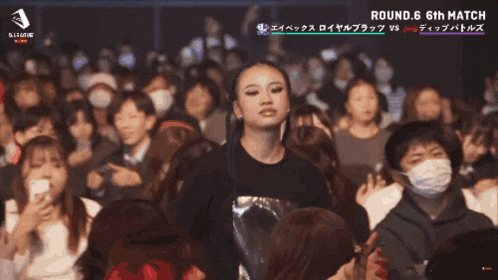 a woman stands in front of a crowd that says coyuki on the bottom