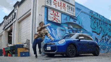 a blue mini cooper is parked in front of a building with asian writing on it