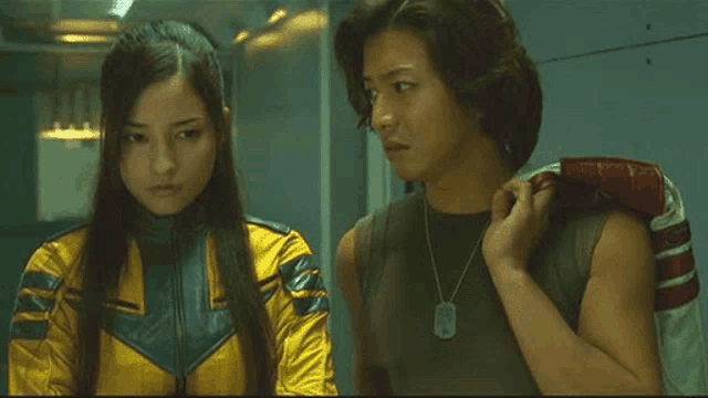 a man and a woman are standing next to each other in a dark room .