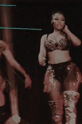 a woman in a bra and thigh high boots is dancing on stage .