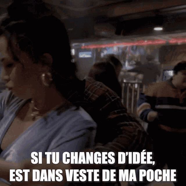 a woman sitting at a table with the words si tu changes d ' ide e est dans veste de ma poche below her