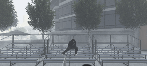 a person sits on a set of bleachers in front of a large building