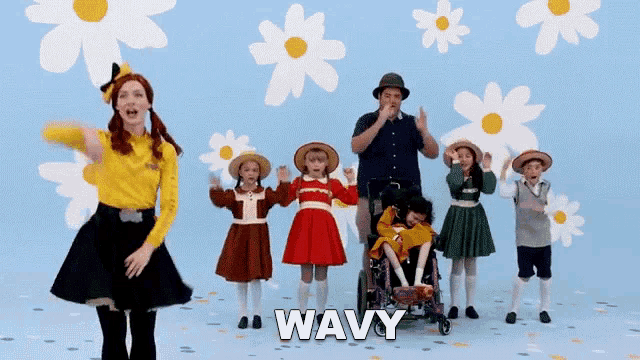 a group of children are dancing in front of a wall that has flowers and the word wavy on it