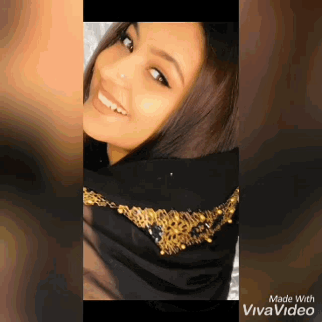a woman wearing a black scarf with gold embroidery is smiling and made with vivavideo