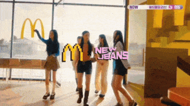 a group of women are dancing in front of a mcdonald 's sign