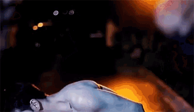 a man without a shirt is crawling in the dark