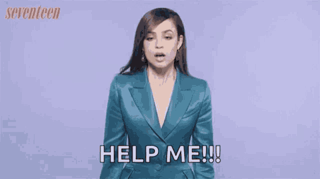 a woman in a blue suit is standing in front of a purple background .