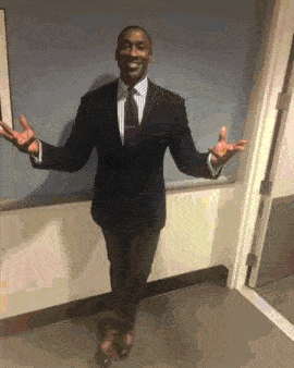 a man in a suit and tie with his arms outstretched