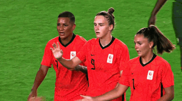 a group of female soccer players hugging one another with one wearing the number 11