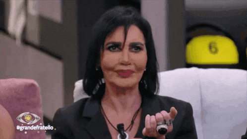 a woman sitting in a chair with the words grandefratello written on the bottom