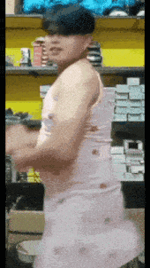a man in a white tank top is standing in front of a shelf of shoes