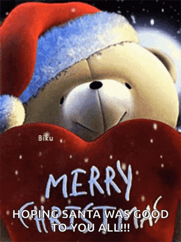 a teddy bear wearing a santa hat is holding a red heart and wishing merry christmas