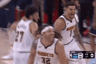 a group of basketball players are standing on a court and celebrating .