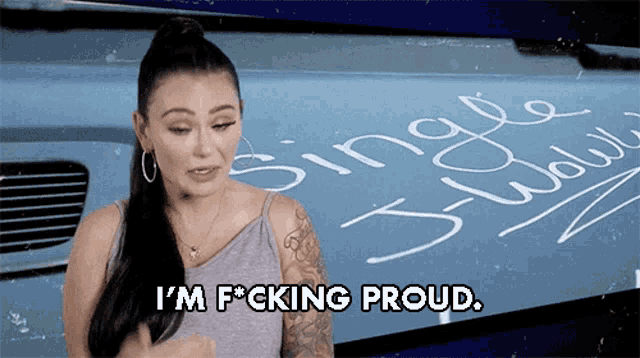 a woman says i 'm f * cking proud while standing in front of a blue truck