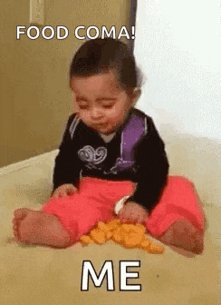 a baby is sitting on the floor with a spoon in his mouth eating cheese .