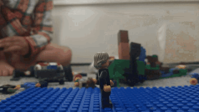 a lego figure standing on top of a blue brick floor