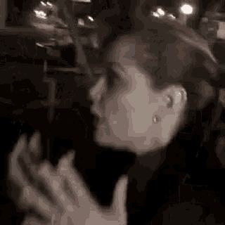 a woman is sitting in a car with her hands outstretched .