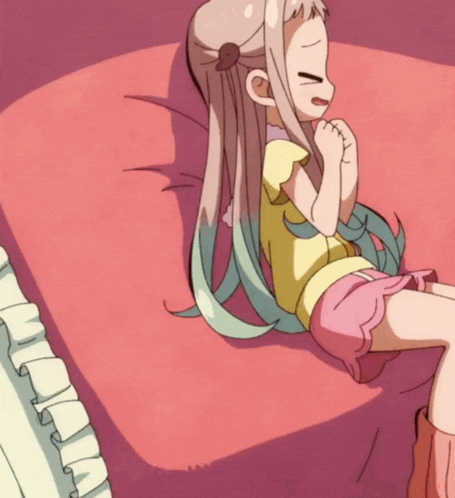 a girl in a yellow shirt and pink shorts is laying on a bed