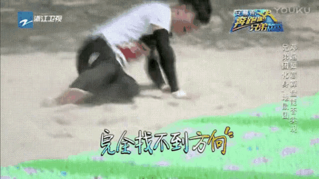 a man is crawling in the sand with chinese writing on the screen