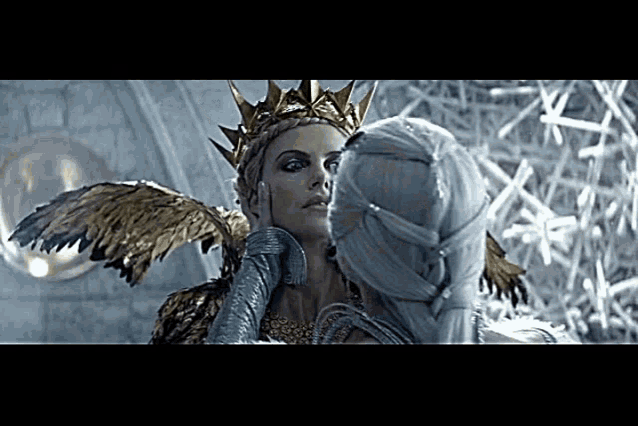 a woman wearing a crown is kissing another woman 's face .