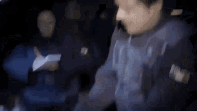 a blurry picture of a group of people sitting at a table eating food .