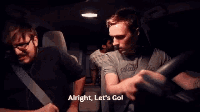 three men are sitting in a car and one of them is saying alright let 's go .