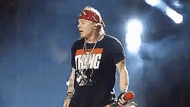 a man is standing on a stage holding a microphone .