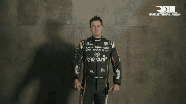 a man in a racing suit with one cure on the front