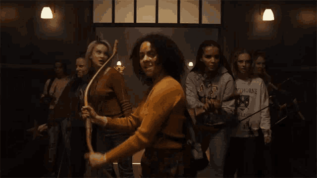 a group of women are standing in a hallway and one of them is wearing a sweatshirt that says thorne on it