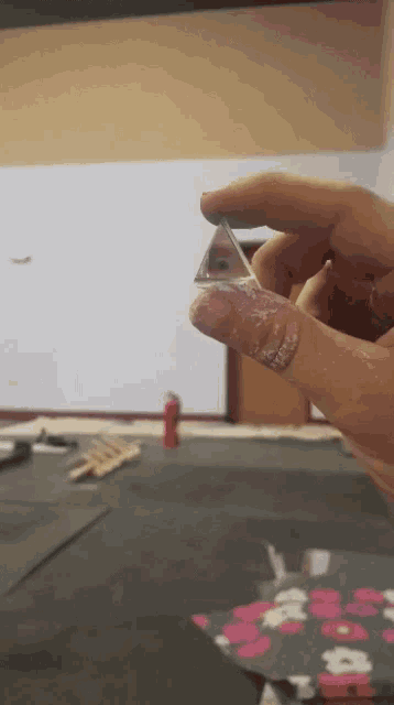 a person is holding a small triangle in their finger