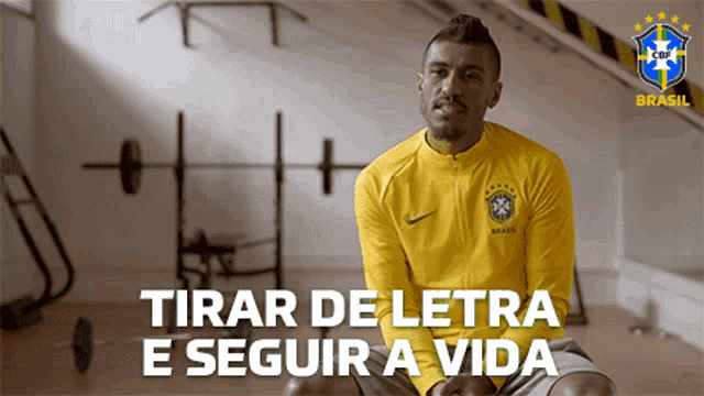 a man in a yellow nike shirt is sitting in a gym with the words tirar de letra e seguir