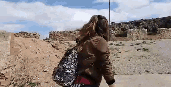 a woman walking with a backpack on her back