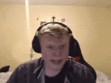 a man wearing headphones is making a funny face while sitting in a chair .