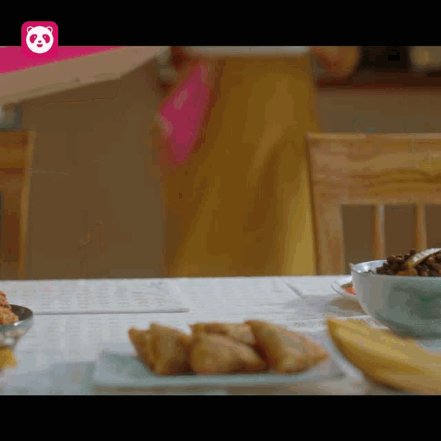 a table with food and a pink panda logo