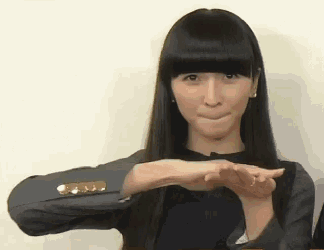 a woman with long black hair making a funny face